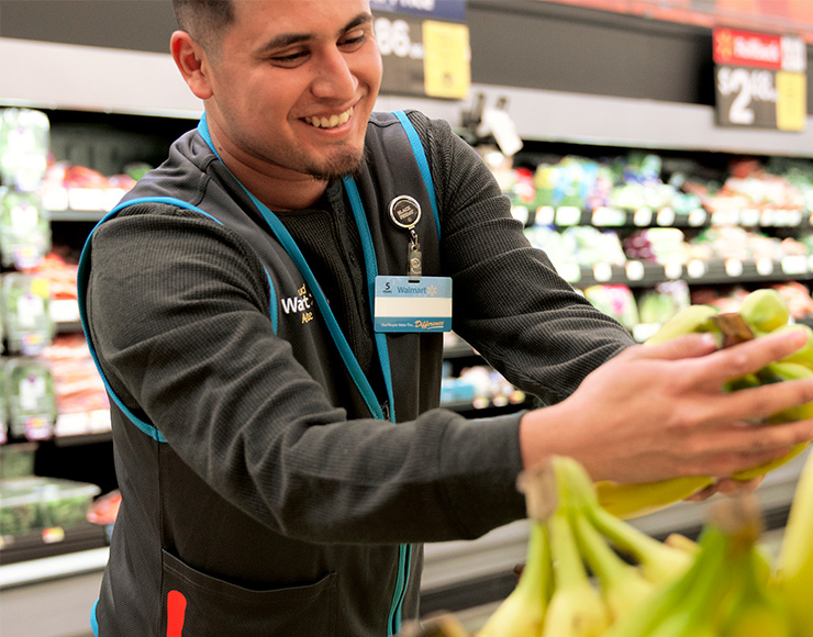 Walmart Associate restocking produce